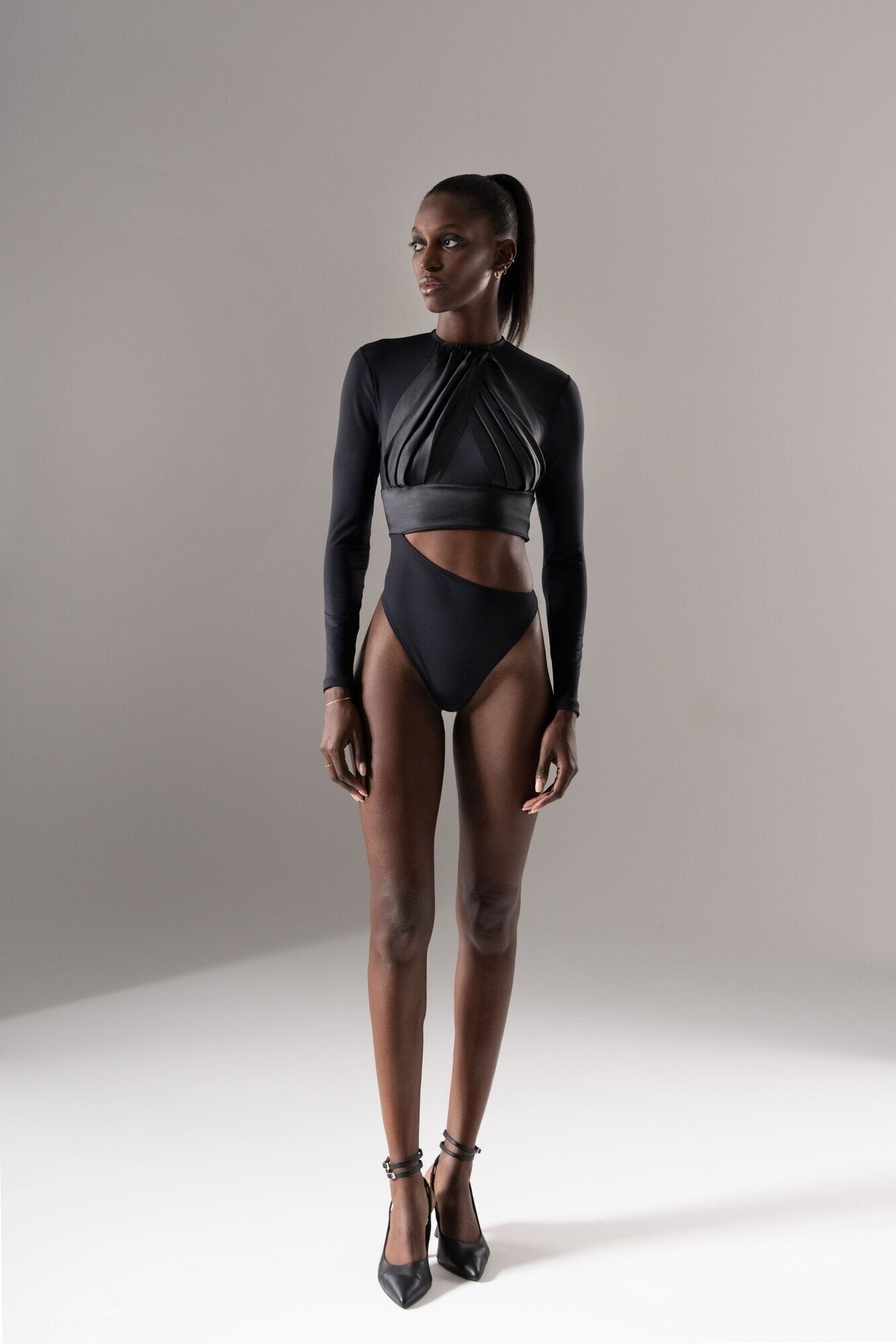 Vue de face du body 02.08 noir, avec jambes nues et escarpins noirs pour un look sexy et élégant.