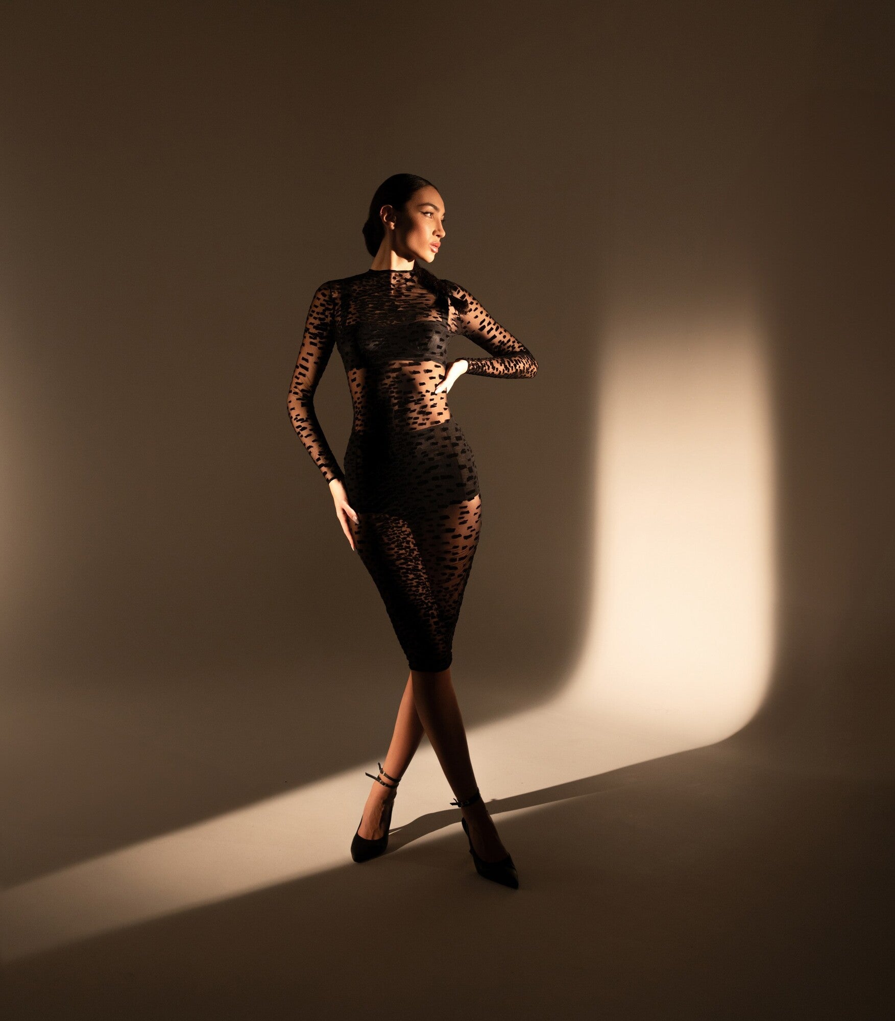 Mannequin en robe noire 11.14 en tulle floqué, marchant dans une lumière rasante, silhouette élégante et graphique