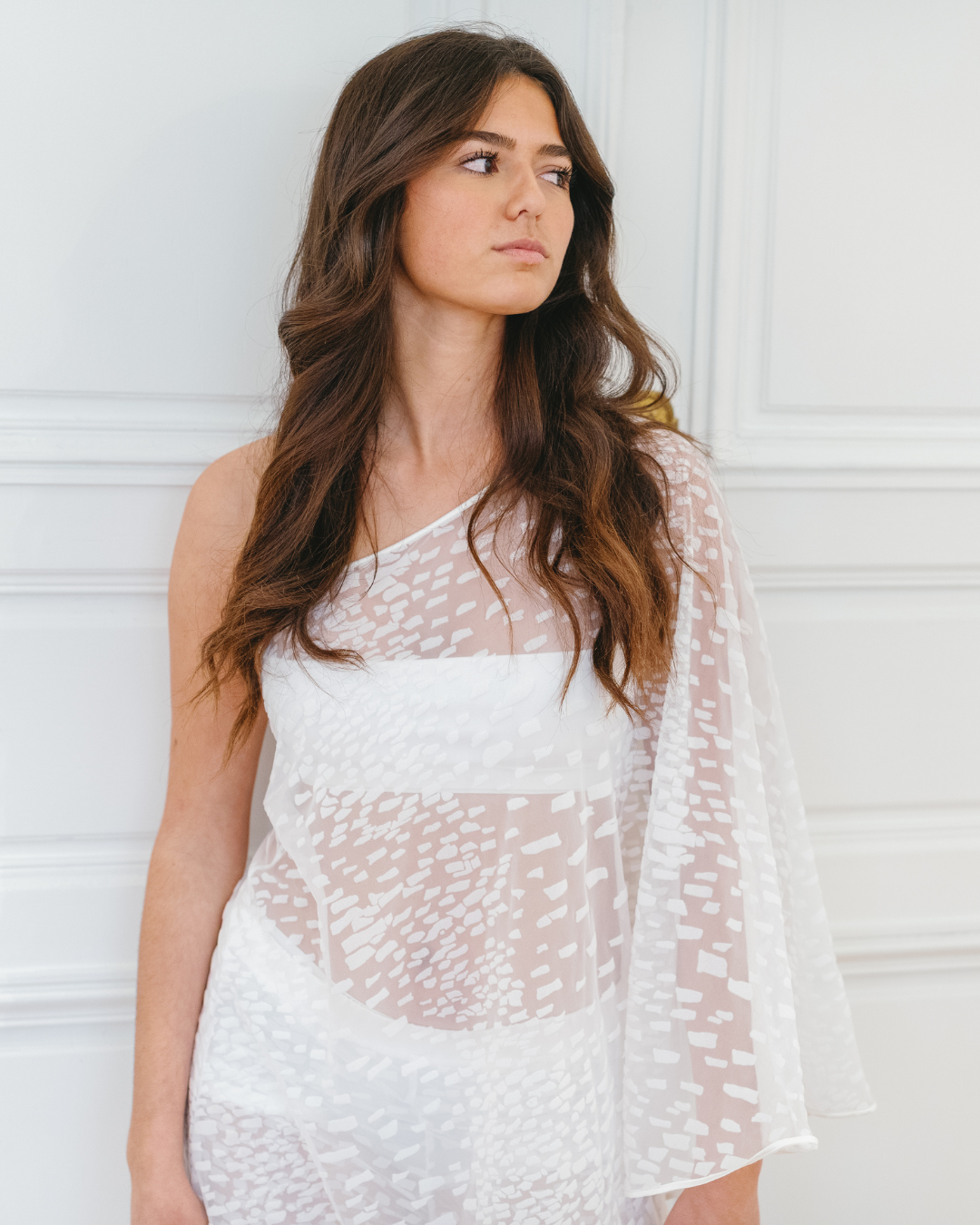 Detail of the Lumey Paris 11.14 white flocked tulle cape top — asymmetric neckline, one bare shoulder, long draped sleeve